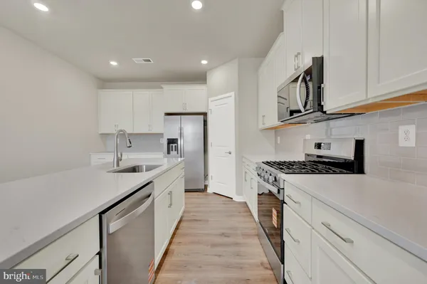 a kitchen with stainless steel appliances granite countertop a sink and stove