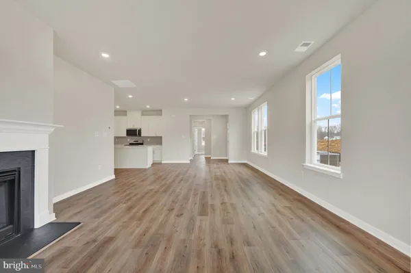 a view of empty room with wooden floor and fireplace