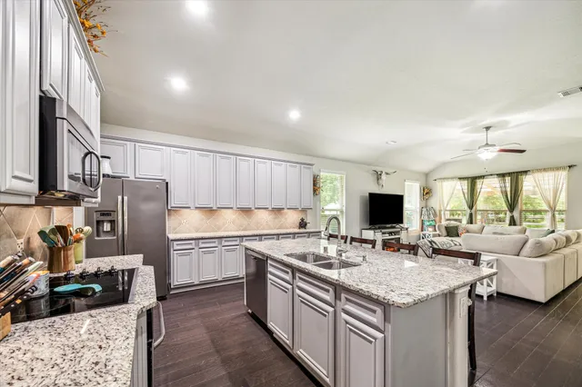 a kitchen with stainless steel appliances granite countertop a sink stove and refrigerator