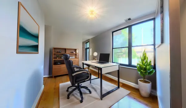 a view of a workspace with furniture and a window