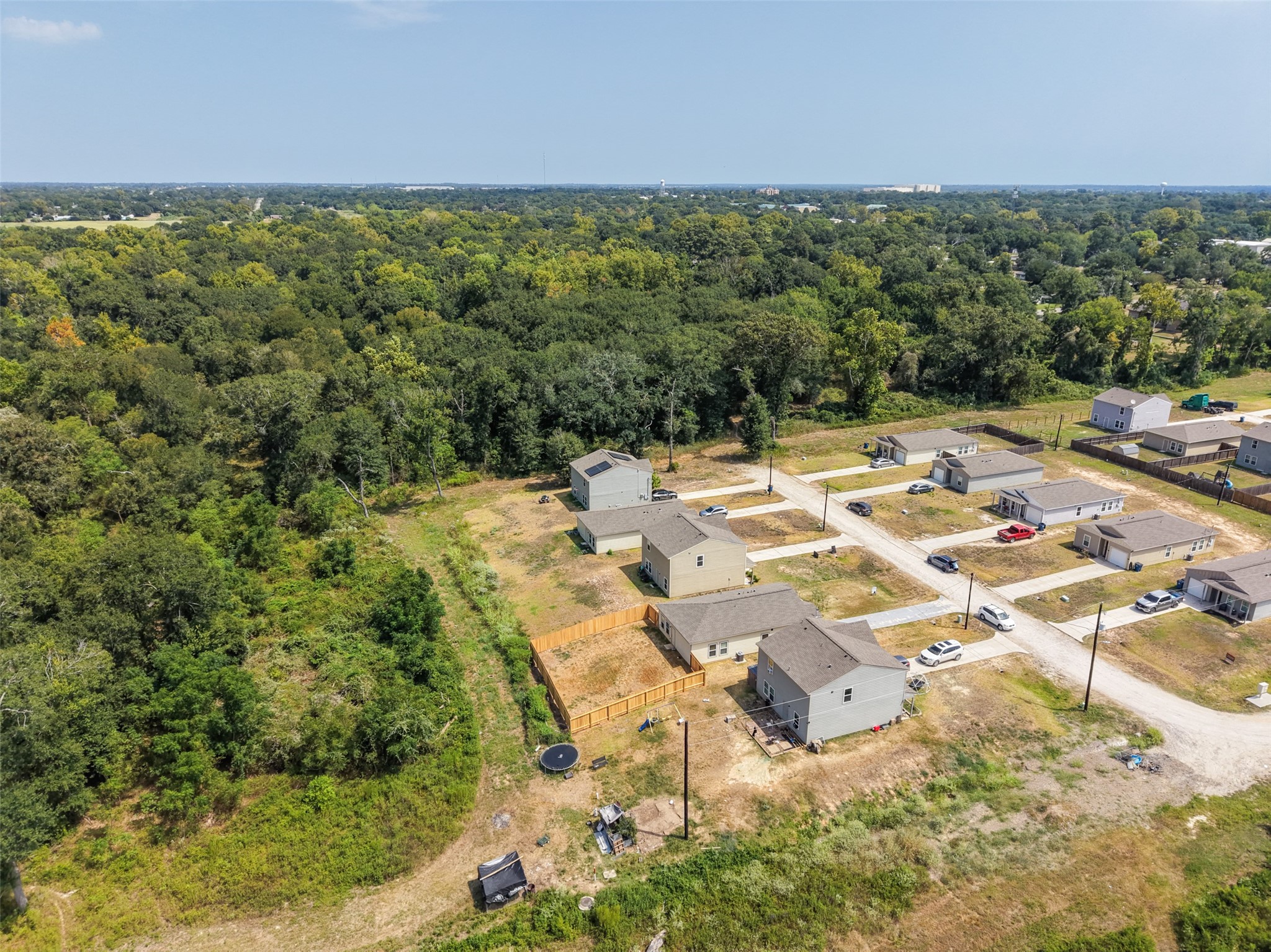 Aerial view showing the neighborhood layout, residential construction, and surrounding natural landscape.