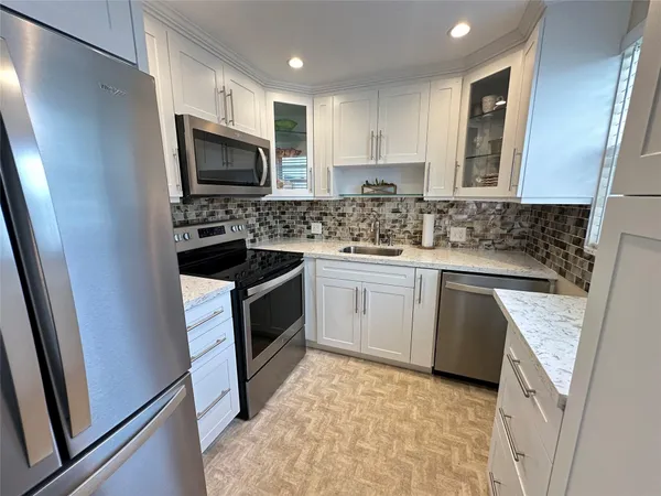 a kitchen with a sink stove microwave and refrigerator
