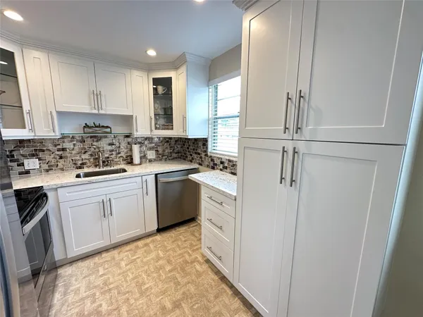 a kitchen with white cabinets and white appliances