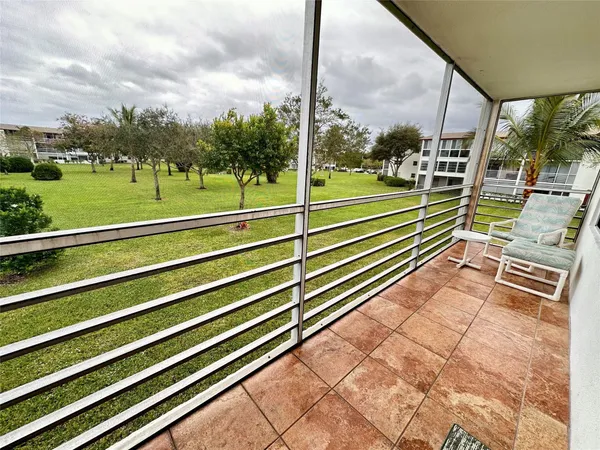 a view of a tennis court with a fountain in the background