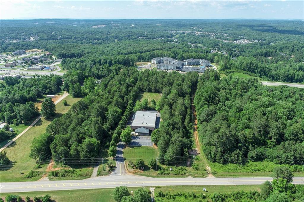 5378 Thompson Mill Road Hoschton, GA 30548 - Photo 5 of 16 an aerial view of a town with trees