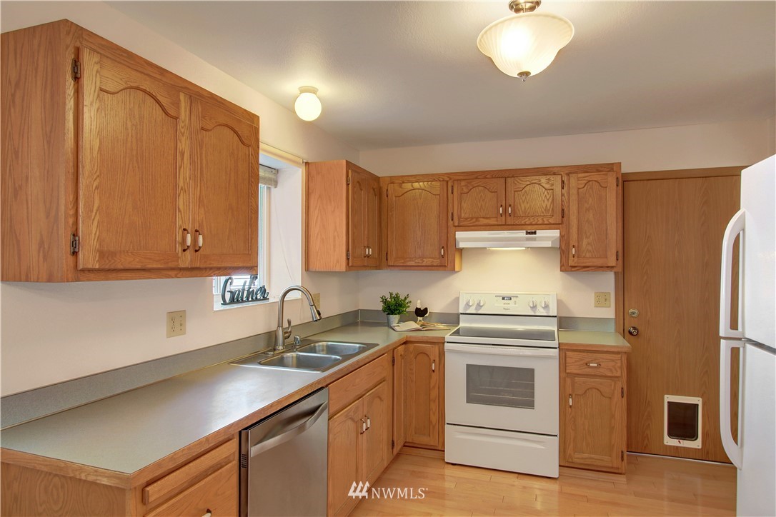2126 164th Place Southeast Bothell, WA 98012 - Photo 7 of 18 a kitchen with stainless steel appliances a sink a stove and a refrigerator