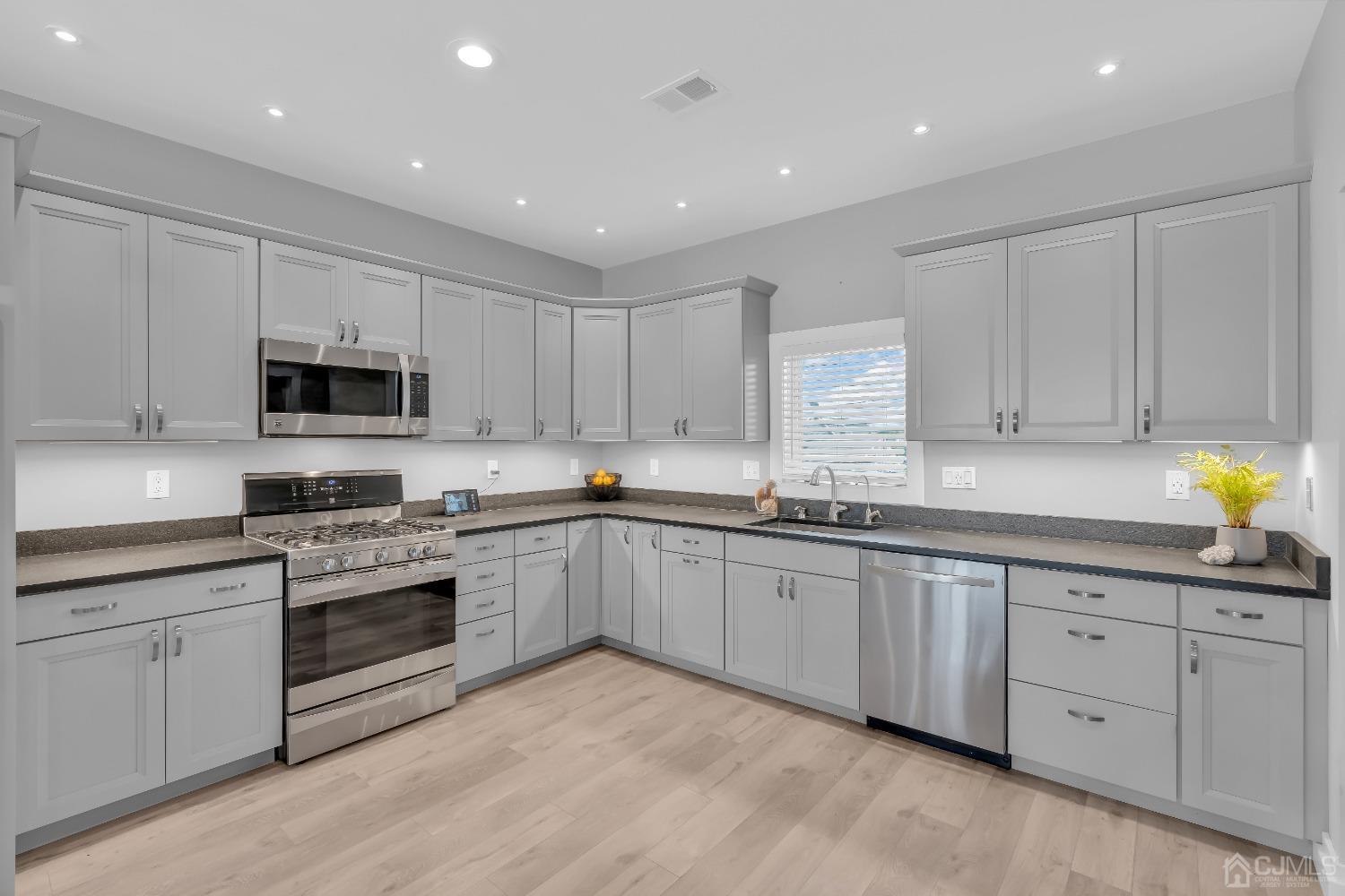 629 Front Street Union Beach, NJ 07735 - Photo 11 of 63 a kitchen with granite countertop white cabinets and stainless steel appliances