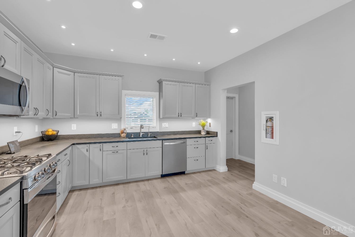 629 Front Street Union Beach, NJ 07735 - Photo 12 of 63 a large kitchen with granite countertop a stove top oven a sink a counter space and cabinets