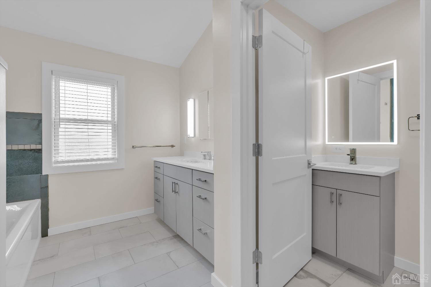 629 Front Street Union Beach, NJ 07735 - Photo 25 of 63 a spacious bathroom with a double vanity sink a mirror and a bathtub