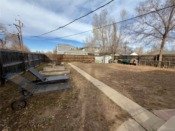 a view of a yard with cars parked on the road