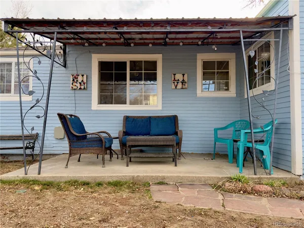 a backyard of a house with barbeque oven table and chairs