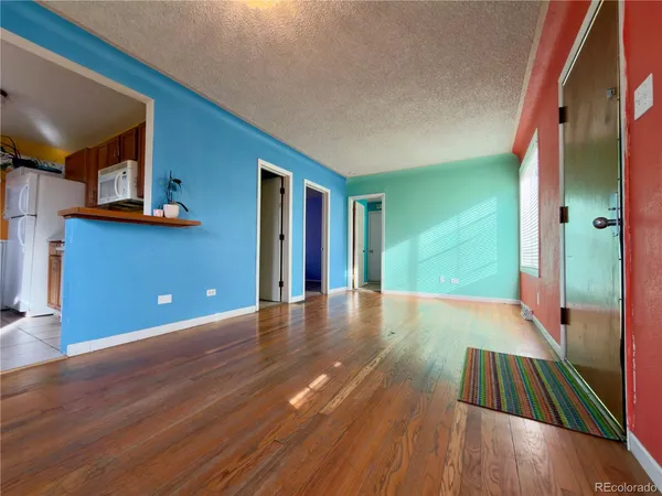 a view of an empty room with wooden floor