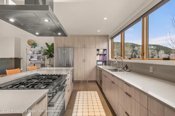 a kitchen with granite countertop a sink stove and cabinets