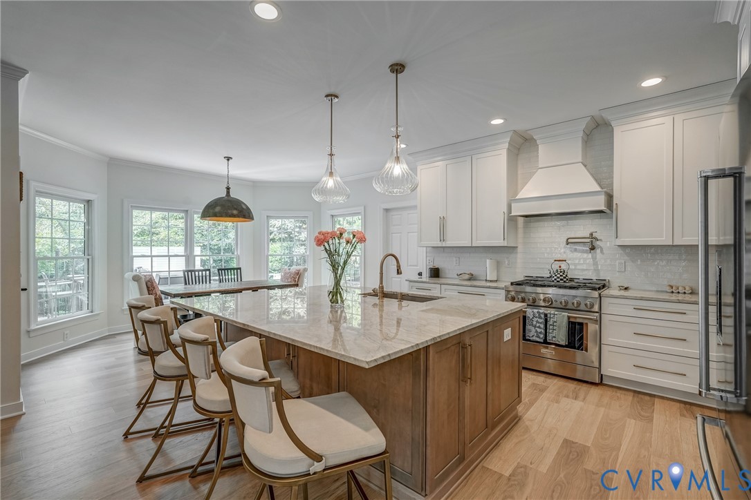 2306 Founders Bridge Road Midlothian, VA 23113 - Photo 17 of 50 a kitchen with stainless steel appliances granite countertop a stove a sink dishwasher a microwave oven and a dining table with wooden floor