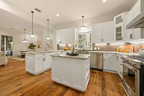 a kitchen with kitchen island granite countertop a stove a sink and a refrigerator