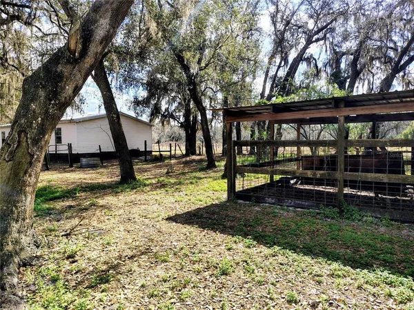 a view of a house with backyard and trees