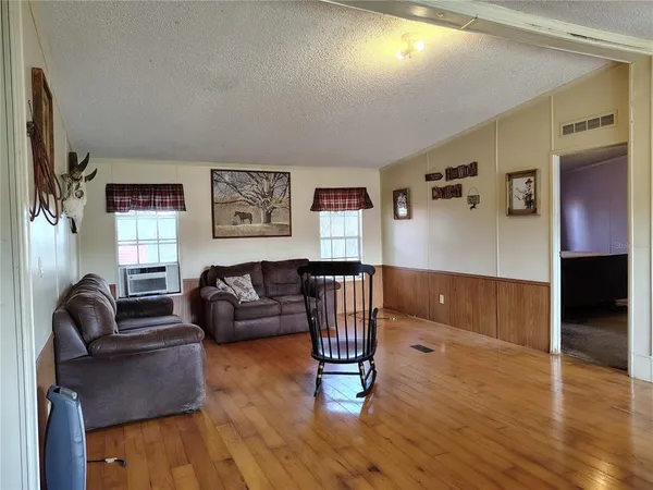 a living room with furniture wooden floor and a table