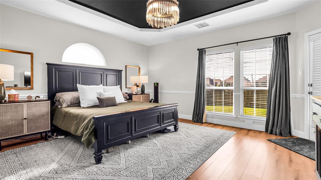 3608 Acropolis Way Plano, TX 75074 - Photo 15 of 37 a spacious bedroom with a large bed and a chandelier