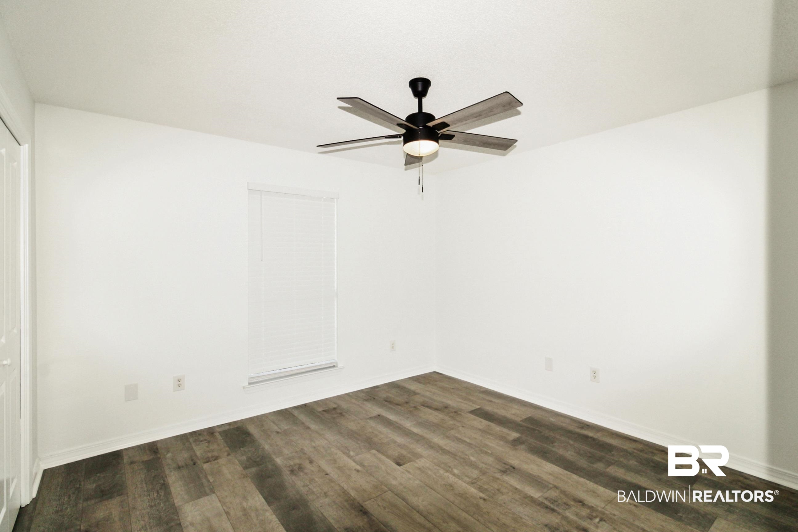 14750 Pawnee Court Foley, AL 36535 - Photo 27 of 34 Empty room with dark wood-style floors and ceiling fan