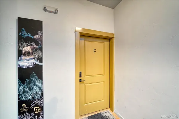 a view of a hallway with wooden floor and closet