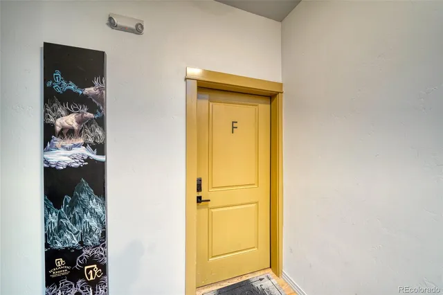 a view of a hallway with wooden floor and closet
