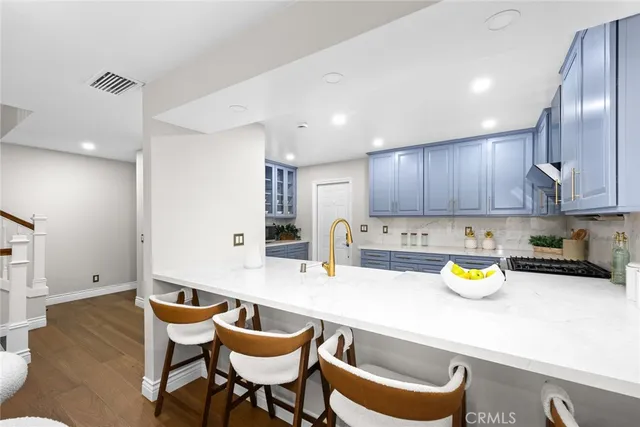 a kitchen with a sink a table and chairs in it
