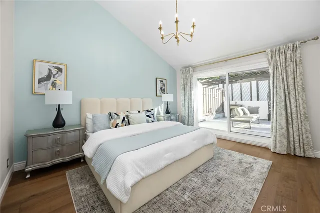 a spacious bedroom with a bed and a chandelier