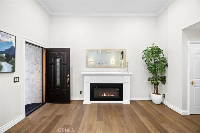 a view of an empty room with wooden floor and a fireplace
