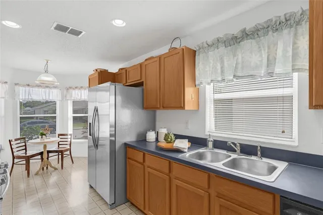 a kitchen with stainless steel appliances granite countertop a sink and a refrigerator