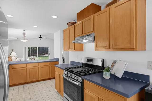 a kitchen with stainless steel appliances granite countertop a sink stove and cabinets