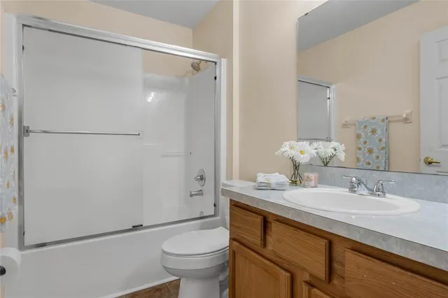 a bathroom with a granite countertop sink mirror toilet and shower