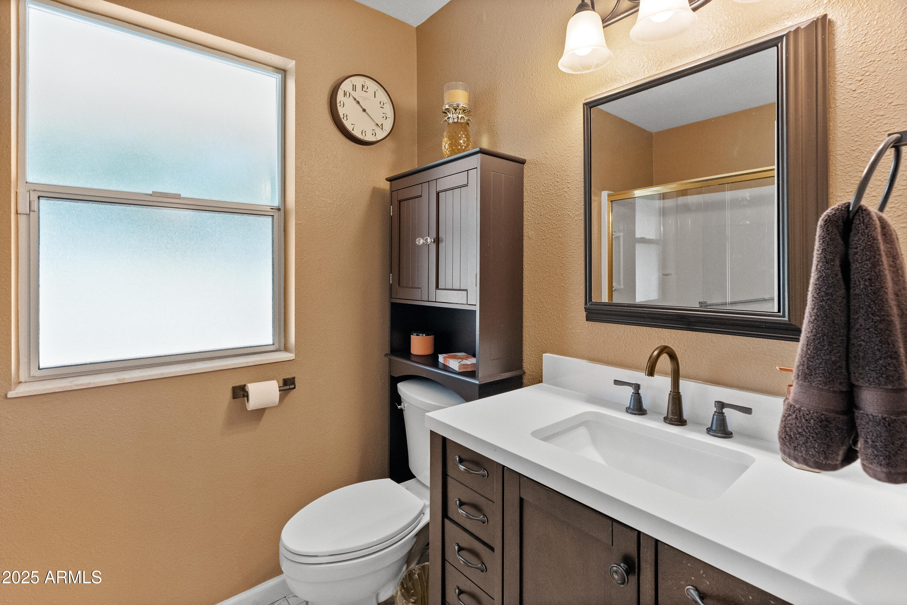 10229 West Bolivar Drive Sun City, AZ 85351 - Photo 23 of 54 a bathroom with a toilet sink vanity and mirror