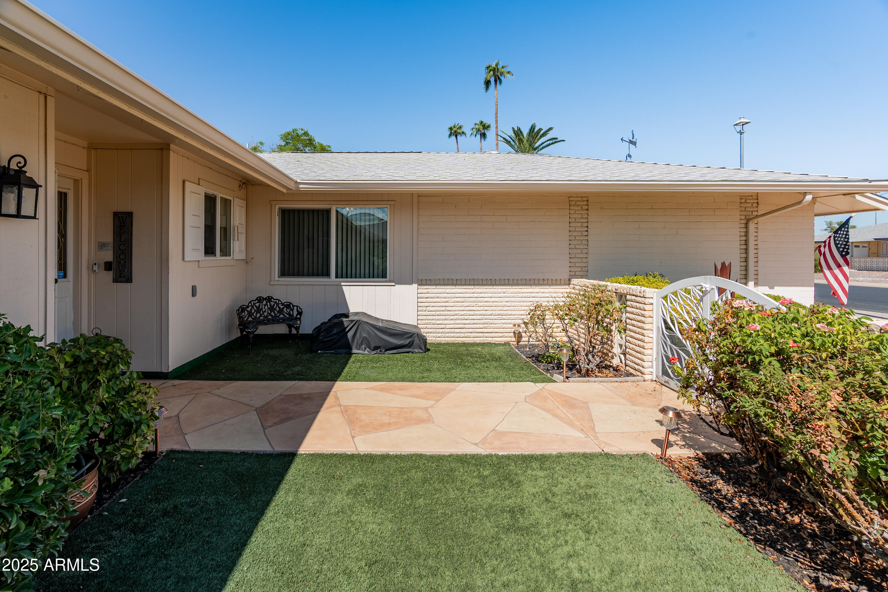 10229 West Bolivar Drive Sun City, AZ 85351 - Photo 52 of 54 a front view of a house with a yard and garage