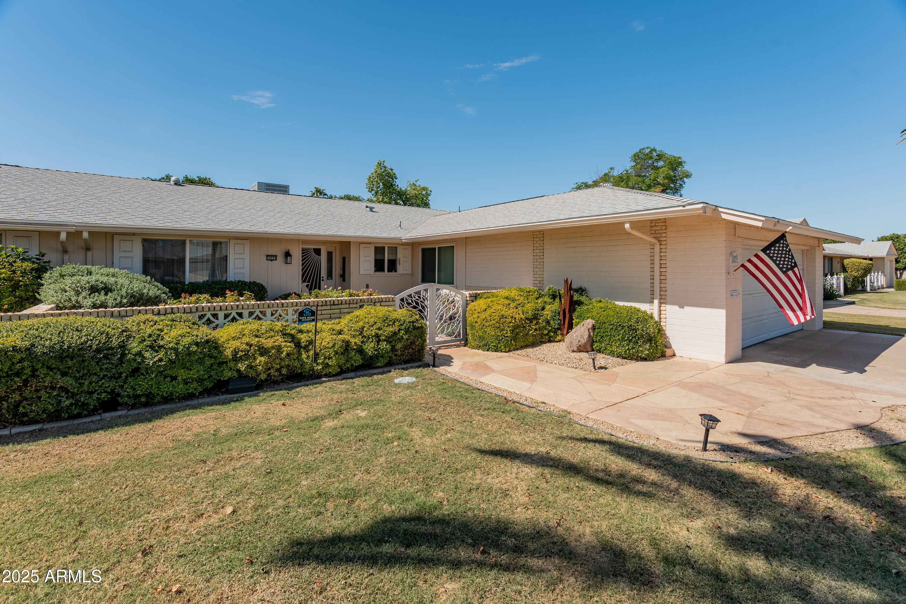 10229 West Bolivar Drive Sun City, AZ 85351 - Photo 53 of 54 a front view of a house with a yard and garage