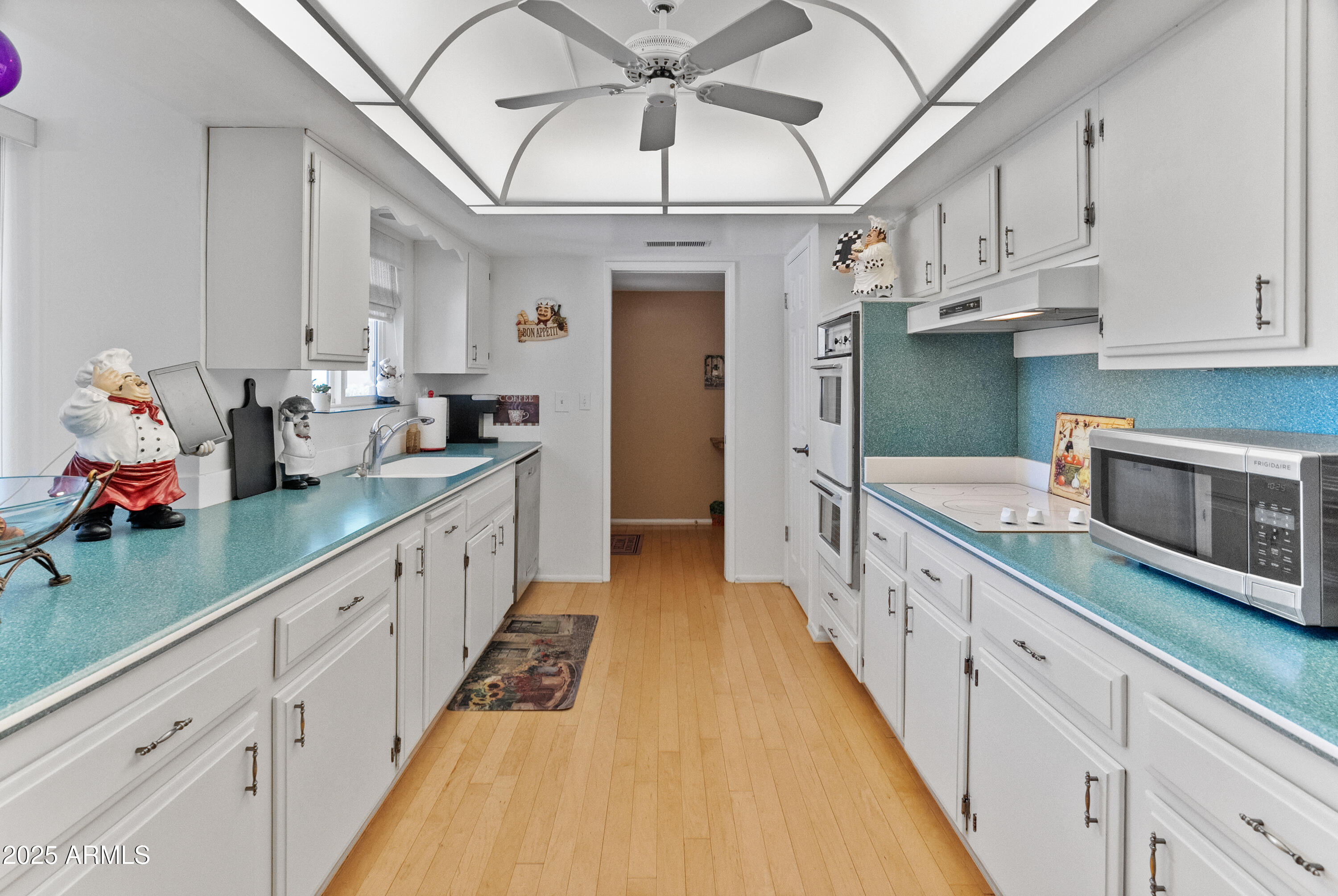 10229 West Bolivar Drive Sun City, AZ 85351 - Photo 9 of 54 a large white kitchen with cabinets a sink and a dishwasher