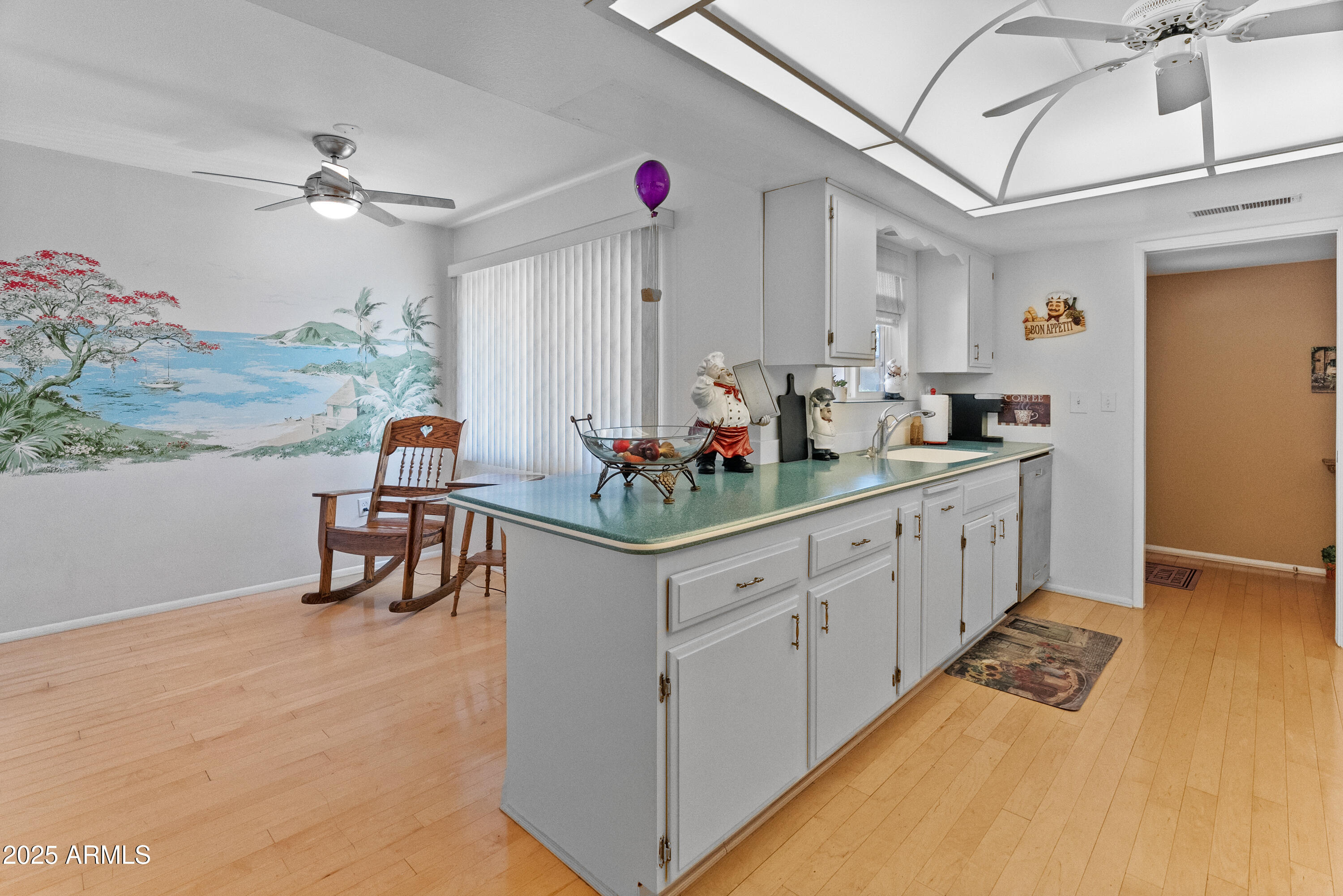 10229 West Bolivar Drive Sun City, AZ 85351 - Photo 10 of 54 a kitchen with stainless steel appliances kitchen island granite countertop a sink and dishwasher with white cabinets