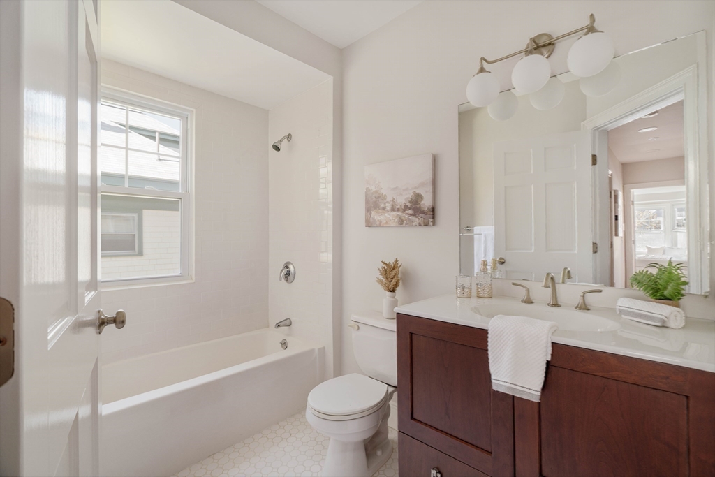 32 Hall Avenue, Unit 32 Somerville, MA 02144 - Photo 18 of 30 a bathroom with a granite countertop sink toilet mirror and bathtub