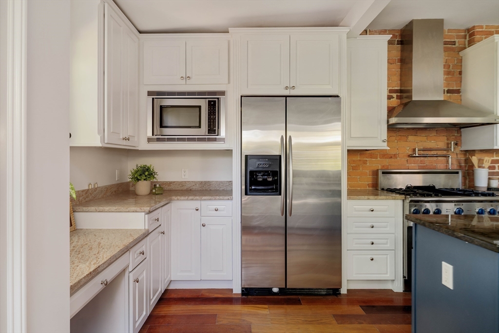 32 Hall Avenue, Unit 32 Somerville, MA 02144 - Photo 7 of 30 a kitchen with stainless steel appliances granite countertop a refrigerator a stove and a sink
