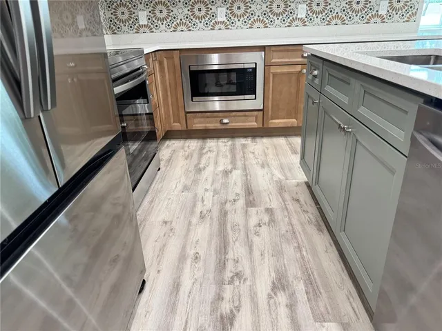 an empty room with wooden floor fan and window