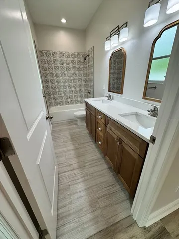a white toilet sitting next to a sink and vanity