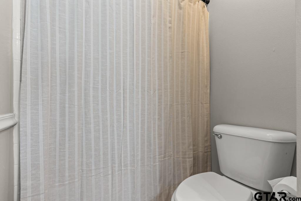 270 Frederick Circle Flint, TX 75762 - Photo 23 of 34 a white toilet sitting next to a shower curtain