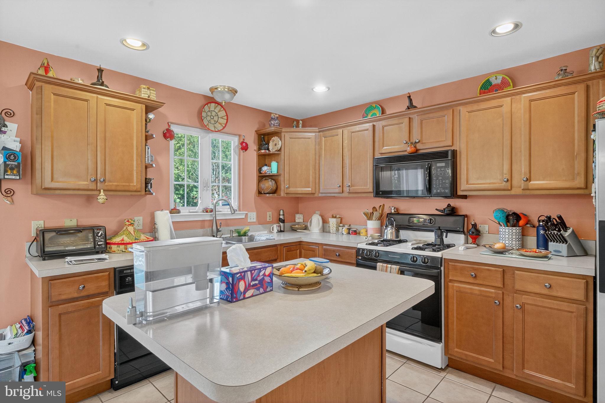 6779 Hickory Road Macungie, PA 18062 - Photo 20 of 51 a kitchen with stainless steel appliances granite countertop a stove a sink dishwasher and a microwave with wooden cabinets