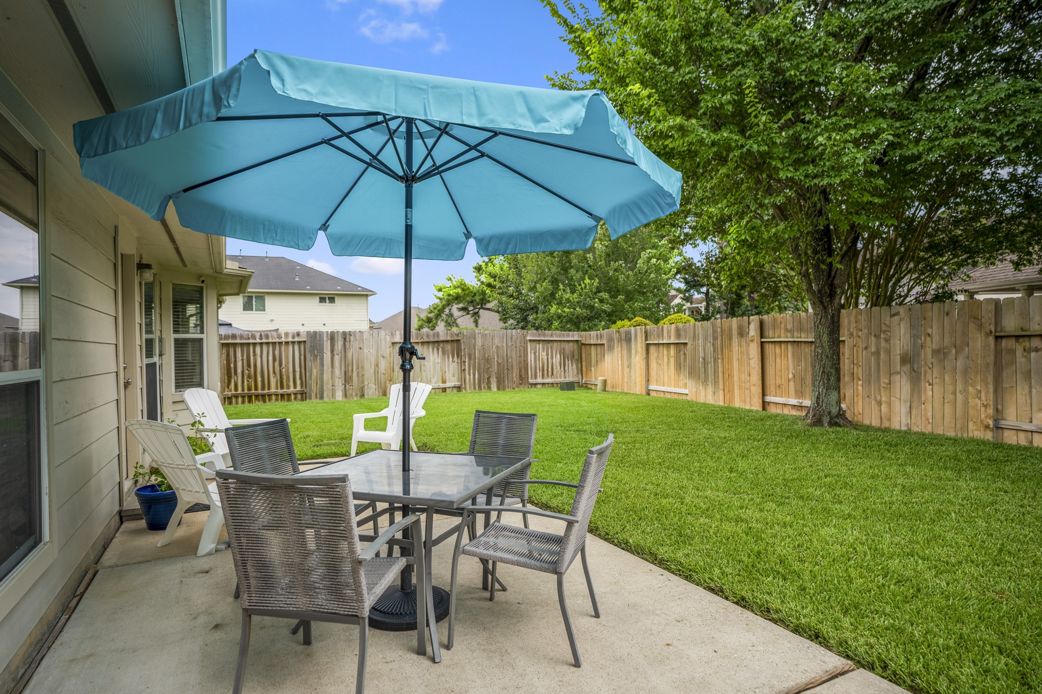 3411 Utah Beach Court Spring, TX 77388 - Photo 34 of 50 Stepping outside, the back patio extends the living space outdoors with room for seating, shade, and an easy connection back into the home. The yard wraps around the patio with green lawn space on both sides, creating a usable outdoor area just beyond the breakfast room and family room.