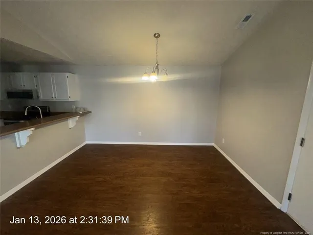 a view of a kitchen with a sink and dishwasher with wooden floor