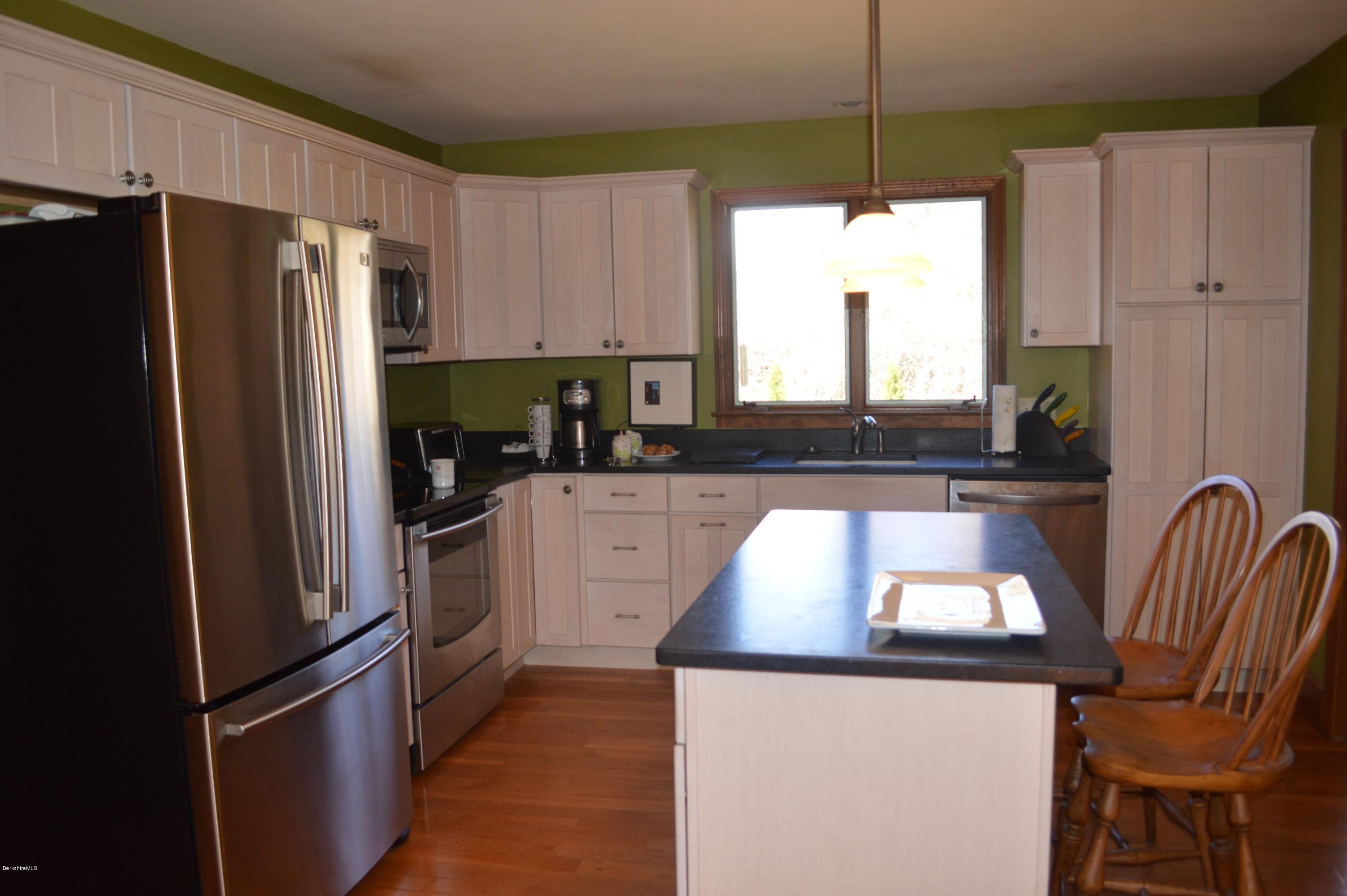 485 Devon Road Lee, MA 01238 - Photo 4 of 28 a kitchen with stainless steel appliances granite countertop a refrigerator a stove a sink and a microwave