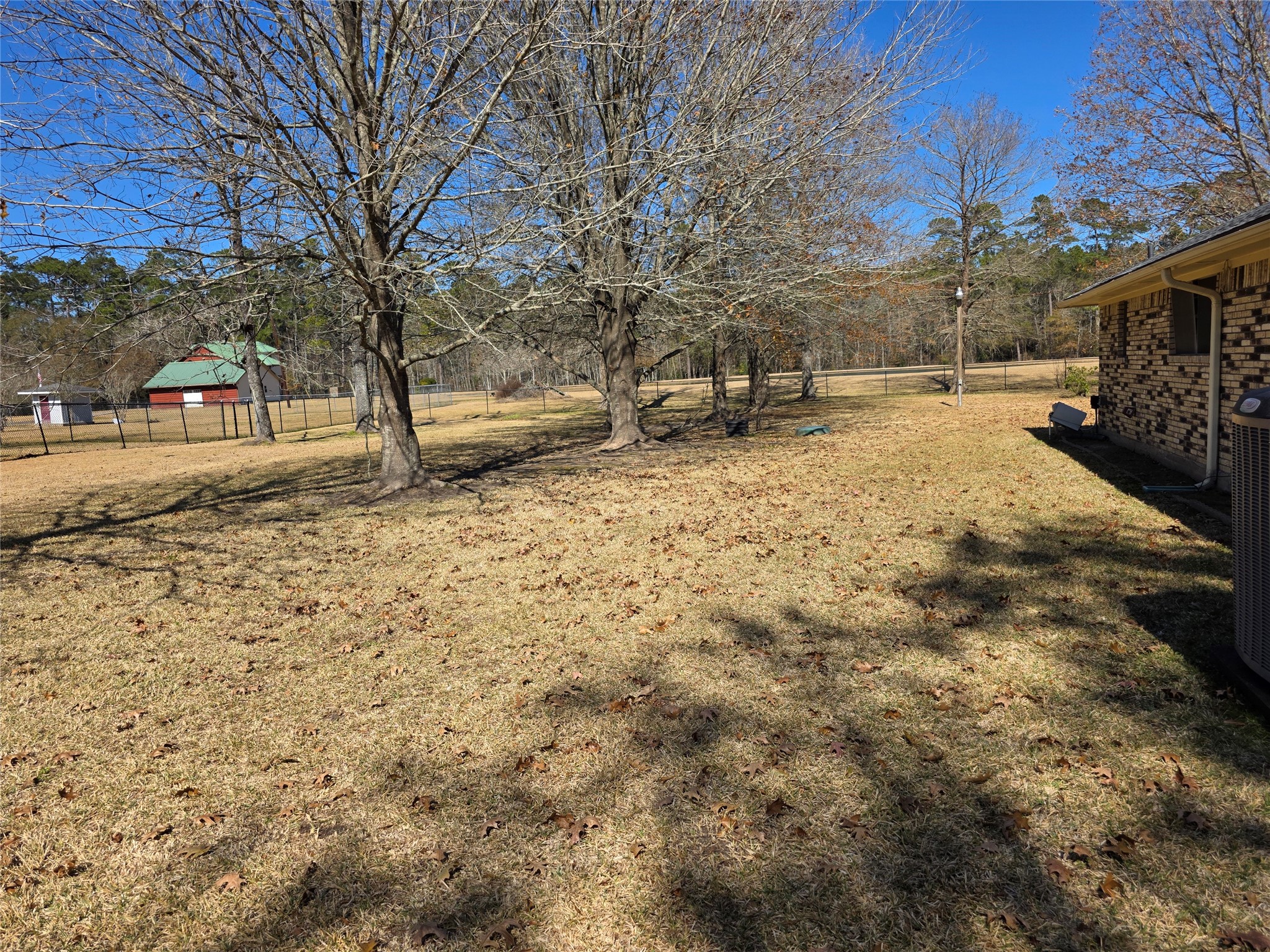 8708 West Fox Road Orange, TX 77632 - Photo 19 of 23 Spacious side yard with mature trees and a fenced area, offering ample room for outdoor activities.