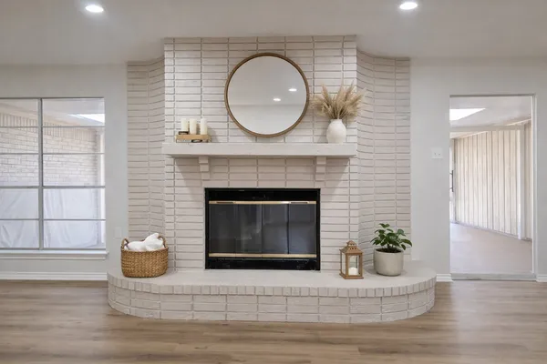 a living room with a fireplace and potted plant