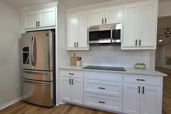 a kitchen with stainless steel appliances white cabinets and a refrigerator