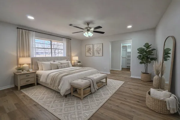 a spacious bedroom with a large bed and a chandelier