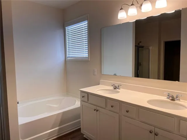 a bathroom with a tub sink and mirror